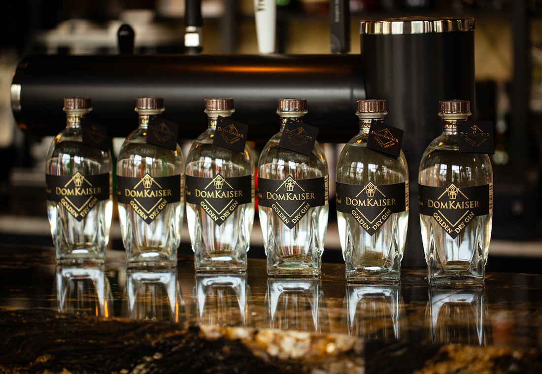 Sechs Domkaiser Golden Dry Premium Gin Flaschen auf Bar-Tresen