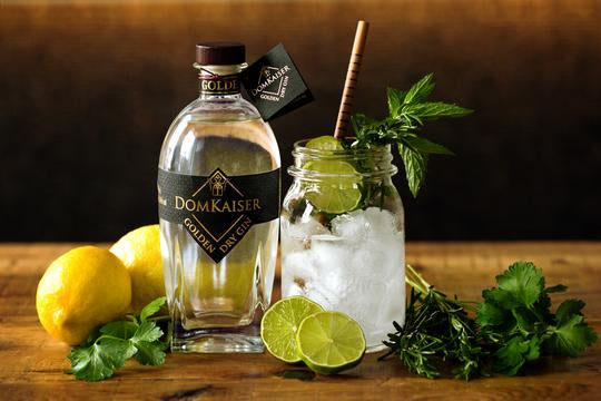 Golden Dry Gin Flasche mit Glas und Botanicals-Deko